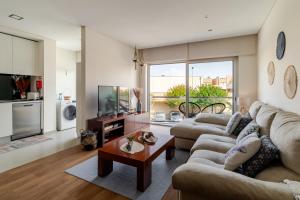 a living room with two couches and a tv at Estrelinha do Mar in Apulia in Apúlia