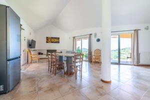 a kitchen and dining room with a table and chairs at Harmònia Residence in Villasimius