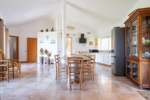 a kitchen and dining room with a table and chairs at Harmònia Residence in Villasimius