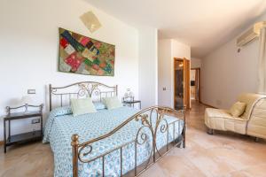 a bedroom with a bed and a couch and a chair at Harmònia Residence in Villasimius +70 photos