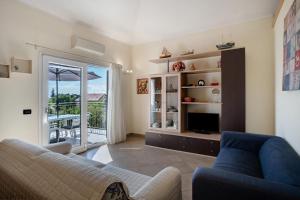 a living room with a couch and a television at Villa di Diana in Diano Castello