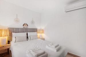 a bedroom with a white bed with towels on it at Villa Alvor Rooftop in Alvor