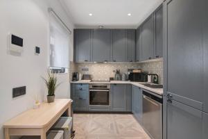 a kitchen with gray cabinets and a wooden table at Villa Alvor Rooftop in Alvor