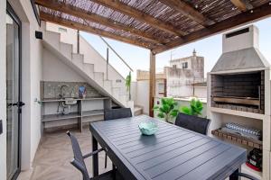 a patio with a table and chairs and a staircase at Villa Alvor Rooftop in Alvor