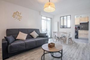 a living room with a couch and a table at Cocooning proche plage in Fréjus