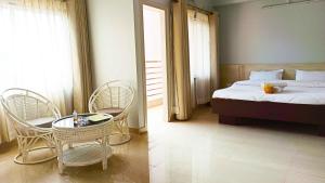 a bedroom with a bed and chairs and a table at Happy Villa Guest House in Guwahati +75 photos