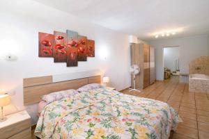 a bedroom with a bed and three paintings on the wall at Montemar 2 in Moya +16 photos