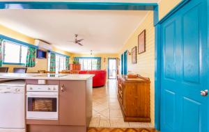 une cuisine avec une porte bleue menant à un salon dans l'établissement Clifton Beach House, à Clifton Beach