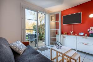 a living room with a couch and a tv at Maison Village Port-Bourgenay in Saint-Hilaire-de-Talmont