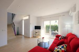 ein Wohnzimmer mit einem roten Sofa und einem Tisch in der Unterkunft Villa Jerónimo in Muro