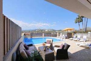 eine Terrasse mit Swimmingpool, Liegestühlen und Sonnenschirm in der Unterkunft Villa Jerónimo in Muro