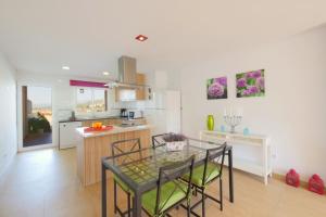 eine Küche und ein Esszimmer mit einem Glastisch in der Unterkunft Villa Jerónimo in Muro