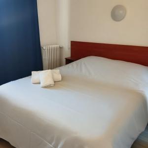a white bed with two pillows on top of it at Hotel Wilson Square in Toulouse