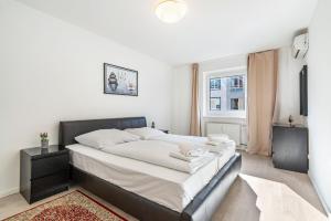 a bedroom with a large bed with a black headboard at Aldars Urban Trio Suite No.5 in Munich
