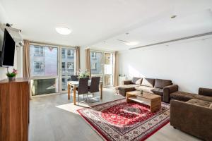 a living room with a couch and a table at Aldars Urban Trio Suite No.5 in Munich