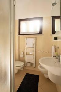 a white bathroom with a sink and a toilet at APT Garda Lake Sirmione con Piscina - FREE PARKING in Sirmione +19 photos