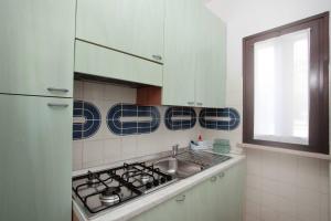 a kitchen with a sink and a stove at APT Garda Lake Sirmione con Piscina - FREE PARKING in Sirmione