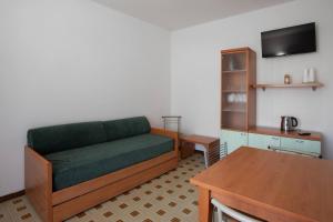a living room with a green couch and a table at APT Garda Lake Sirmione con Piscina - FREE PARKING in Sirmione