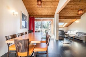 a dining room with a wooden table and chairs at Gîte Le Jorat - Appartement C in Bogève