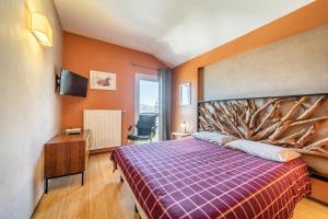 a bedroom with a large bed with a tree headboard at Gîte Le Jorat - Appartement C in Bogève