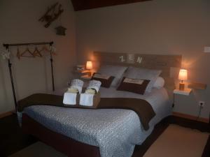 a bedroom with a bed with pillows and two lamps at Chambre d'hôtes Le Nid'zen in Le Nizan +20 photos
