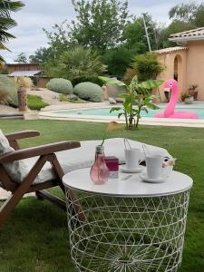 a table with two cups and a vase on it at Chambre d'hôtes Le Nid'zen in Le Nizan