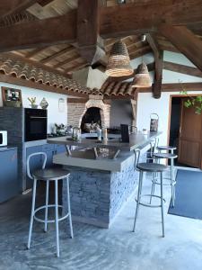 a kitchen with a counter and bar stools at Chambre d'hôtes Le Nid'zen in Le Nizan