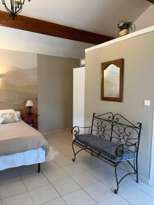 a bedroom with a bed and a mirror and a bench at A La Cour Basse in Peltre