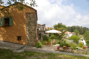 a stone building with a table and chairs in a yard at Casa Vittorina in Cesio