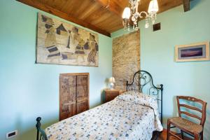 a bedroom with a bed and a chair at Casa Vittorina in Cesio