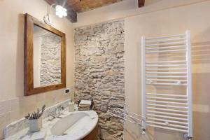 a bathroom with a sink and a stone wall at Casa Vittorina in Cesio +21 photos