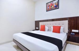 a bedroom with a large white bed with red pillows at Hotel West Guest House in Gangtok