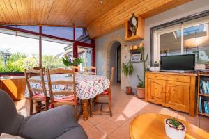 a living room with a table and a television at Gite Refuge du Blavet 2 étoiles in Saint-Barthélemy
