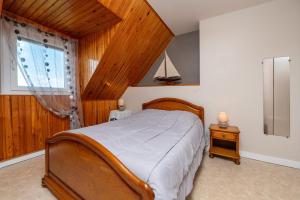 a bedroom with a wooden bed and a window at Gite Refuge du Blavet 2 étoiles in Saint-Barthélemy