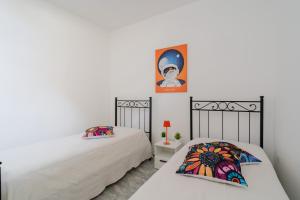 a bedroom with two beds and a painting on the wall at Kalès home in Otranto in Otranto