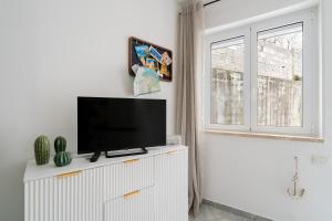 a flat screen tv sitting on top of a white cabinet at Kalès home in Otranto in Otranto