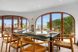 a dining room with a table and chairs and windows at Caroix in Jávea