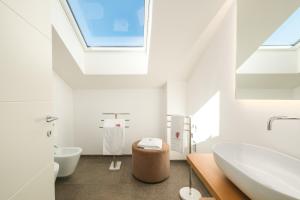 ein weißes Badezimmer mit Oberlicht und Waschbecken in der Unterkunft Maso Renner in Leifers + 286 Fotos