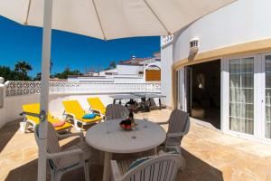 a patio with a table and chairs and an umbrella at Villa Encantada in Arona