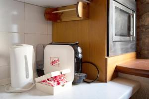 a kitchen with a refrigerator and a box on a counter at Maison Jaccod_piano terra in Morgex