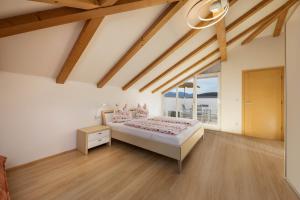 a bedroom with a bed and a large window at Stompferhof Mansarde in Caldaro +11 photos