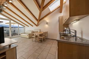 a kitchen with a sink and a table with chairs at Stompferhof Mansarde in Caldaro