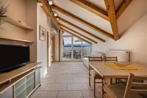 a kitchen and dining room with a table and a television at Stompferhof Mansarde in Caldaro