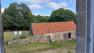 an old stone building with a red roof at Chambres d'hôtes pleine nature in Plougonven