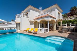 a villa with a swimming pool in front of a house at Villa Encantada in Arona