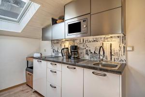 a kitchen with white cabinets and a sink at Residence Kronstein - Fewo 9 in Tesimo +11 photos