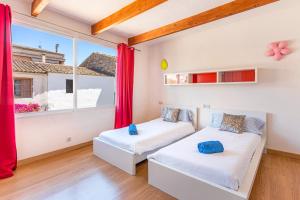 a bedroom with two beds and a large window at Ca Sa Cristeta de Sescola in Sa Pobla