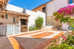 a courtyard of a house with pink flowers at Ca Sa Cristeta de Sescola in Sa Pobla