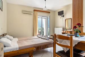 a bedroom with a bed and a table and a window at Daratos studio 2 in Kefallonia