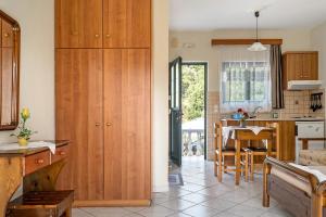 a kitchen with wooden cabinets and a table in a room at Daratos studio 2 in Kefallonia +16 photos